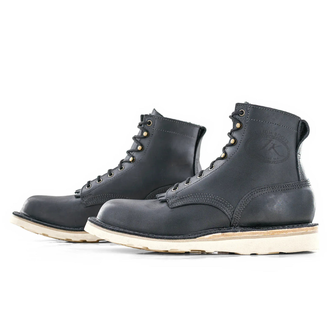 Side view of a pair of Forefront black leather work boots on a white background