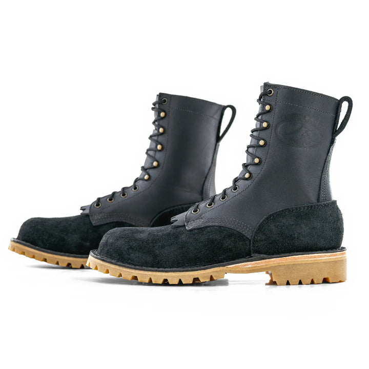 Side view of a pair of OT Black leather rough work boots on a white background