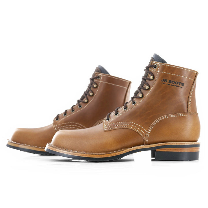 Side view of a pair of Archer light brown heritage leather boots on a white background