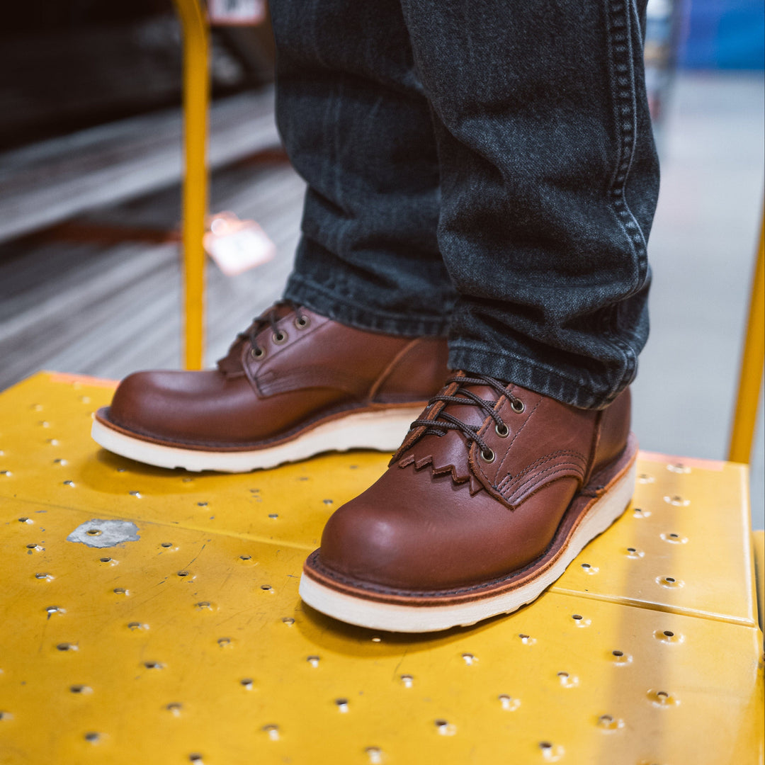 Pair of Forefront redwood leather work boots being worn by a person standing on a step ladder