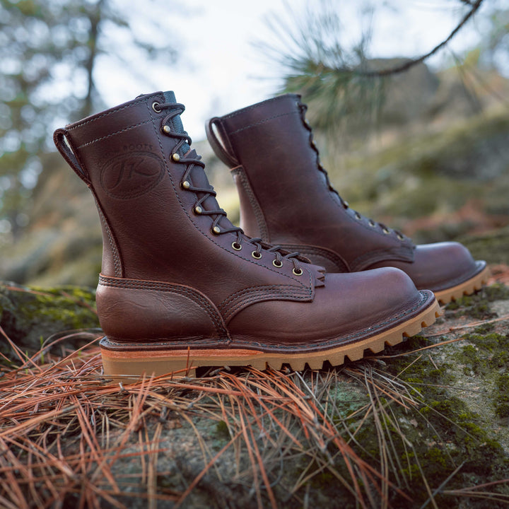 Pair of OT Brown leather work boots on a rock and pine needles