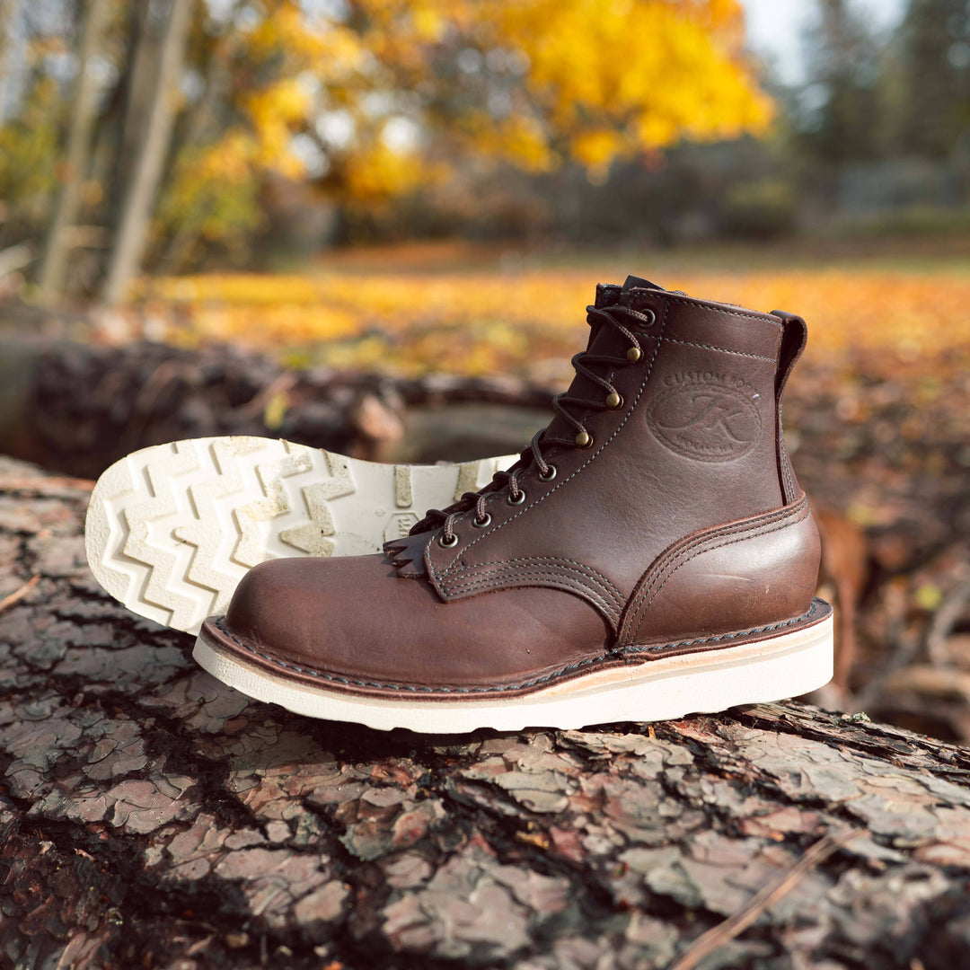 Pair of brown Forefront leather work boots sitting on a tree