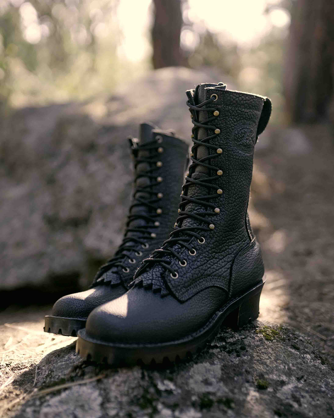 Profile view of a pair of Superduty shadow bison leather boots on a rock