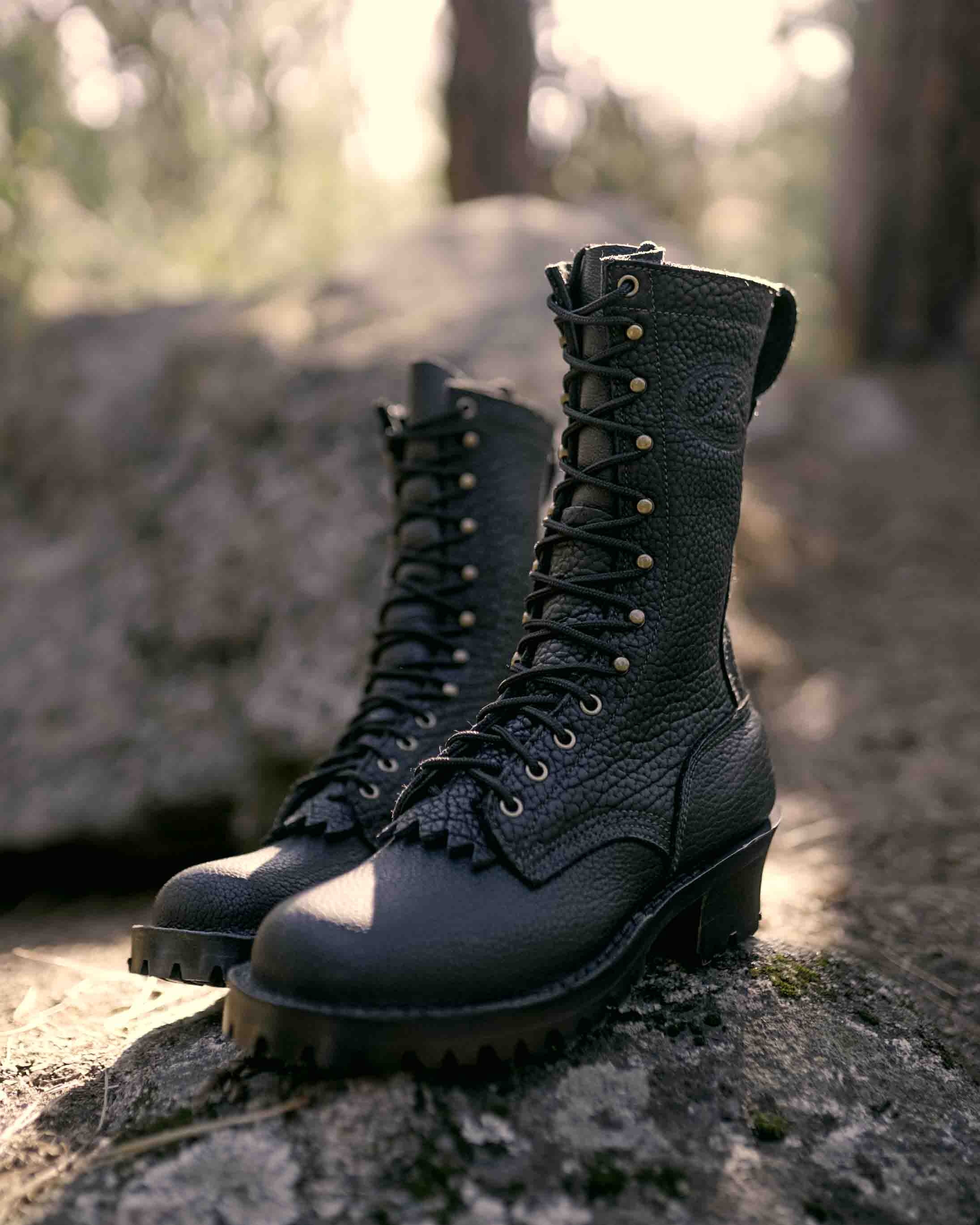 Profile view of a pair of Superduty shadow bison leather boots on a rock